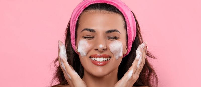 Girl is washing face with foaming facial cleanser