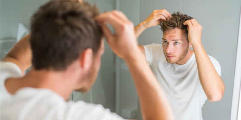 a person looking at his hair issues