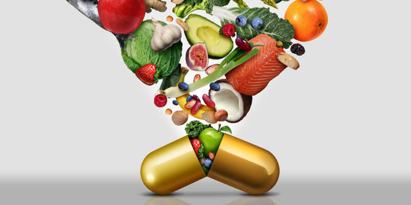 a capsule with fruits and vegetables falling out of it