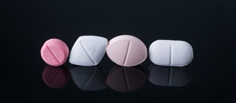 a row of Gradyn Plus pills on a black surface