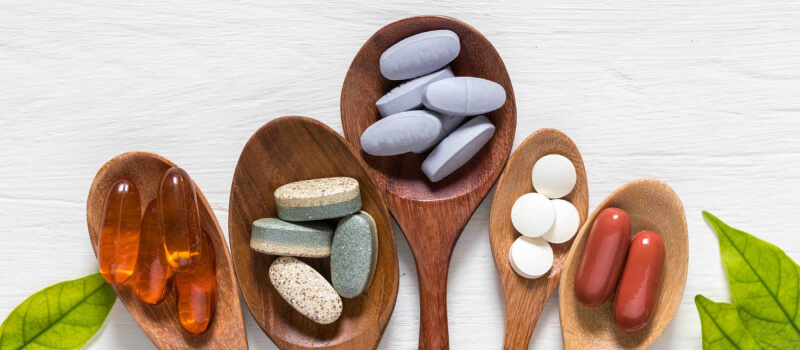 a group of wooden spoons with different pills