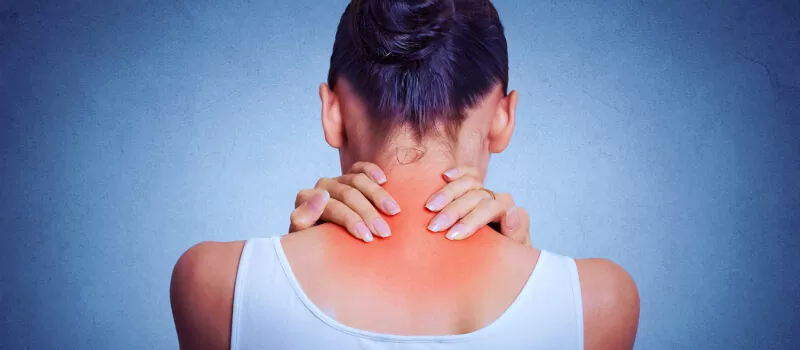 a woman holding her neck and shoulder