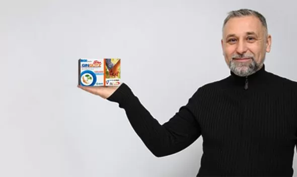 A man holds a box of cereal, promoting the incorporation of Ginglitz Plus into his daily routine.