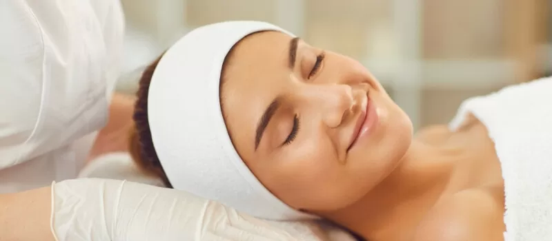 A woman receives a facial treatment in a serene spa, emphasizing the magic of collagen for enhancing skin health.